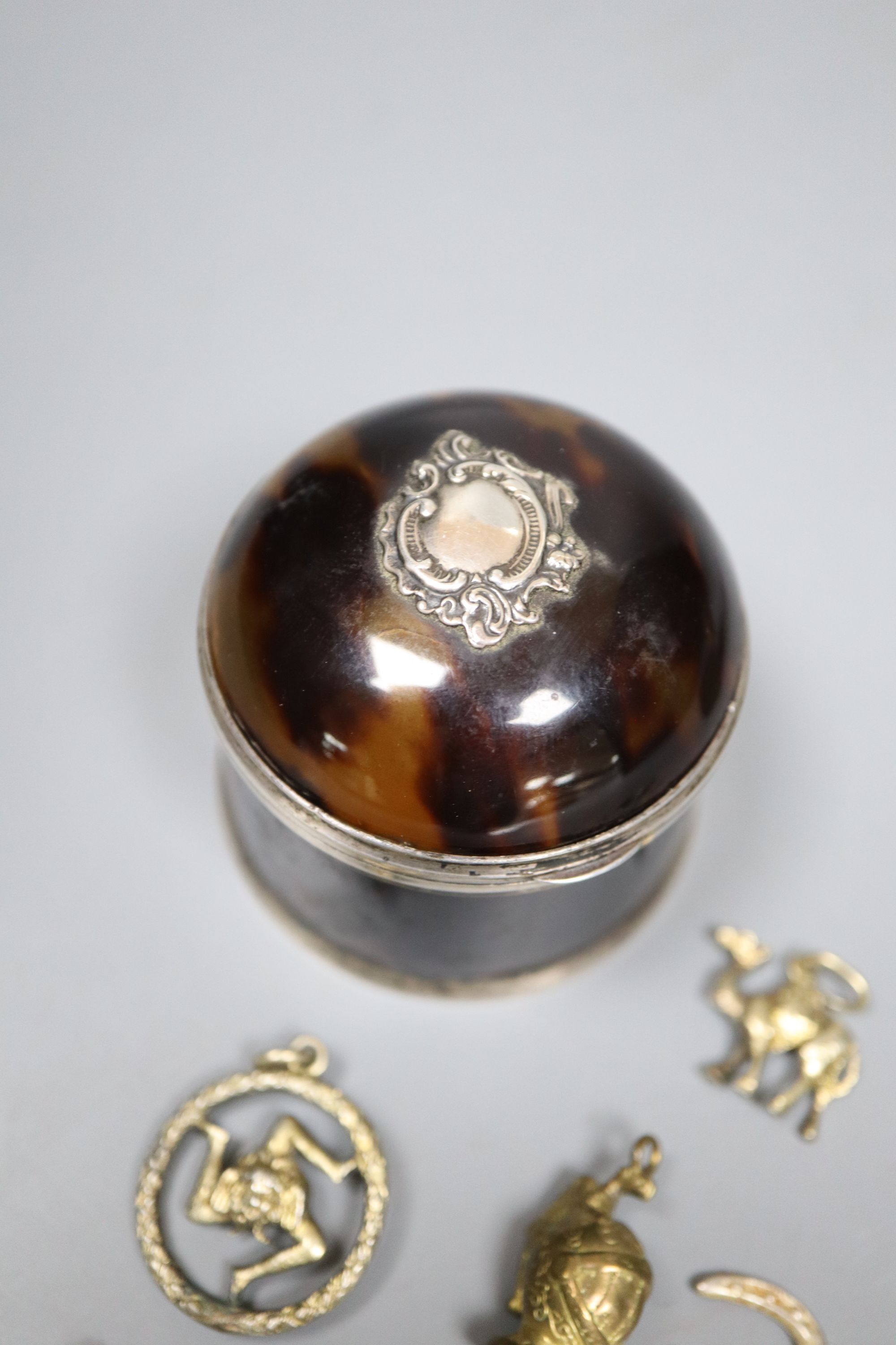 A late Victorian silver mounted tortoiseshell box, (a.f.) one other base metal box and a group of assorted metal charms.